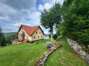 a house on a hill with a stone wall at Pensjonat Marzenie in Przesieka
