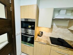 a small kitchen with a stove and a microwave at Luxury Penta Square DHA Apartments in Lahore