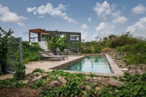 a home with a swimming pool and a house at T3 Moderne avec piscine Oasis de nature et Sérénité in Petit-Canal