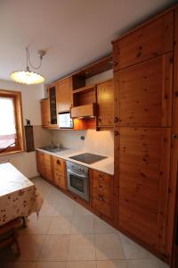 een keuken met houten kasten en een fornuis bij Appartamento Federici in Bormio