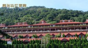 a large building with red roofs on a mountain at Wan Ruey Resort in Hengshan