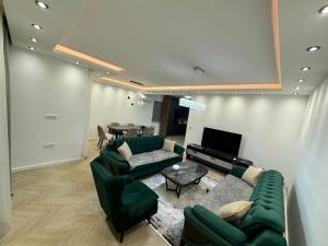 a living room with green couches and a table at Villa SA in Ravanj