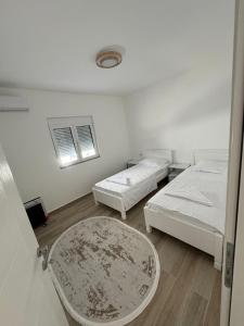 a room with two beds and a table at Villa SA in Ravanj