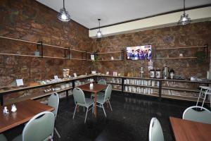 ein Restaurant mit Tischen und Stühlen und einer Backsteinmauer in der Unterkunft Hotel Plaza in Salta
