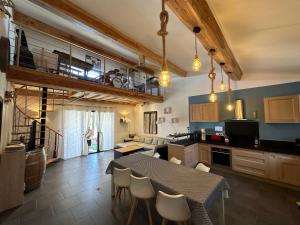 eine Küche und ein Esszimmer mit Tisch und Stühlen in der Unterkunft Maison Isle sur la sorgue in LʼIsle-sur-la-Sorgue