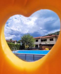 a view of a swimming pool through a heart shaped window at La Casina di Sotto in Castelnuovo di Garfagnana