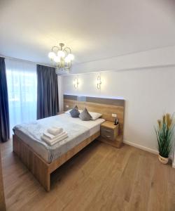 una camera da letto con un letto grande e un lampadario di Ultracentral Luxury Apartament a Curtea de Argeş