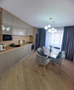 una cucina e una sala da pranzo con tavolo e sedie di Ultracentral Luxury Apartament a Curtea de Argeş Altre 15 foto