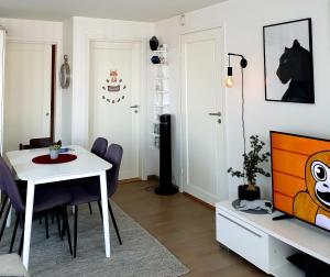 a living room with a white table and a tv at Kabelvåg Apartment in Kabelvåg