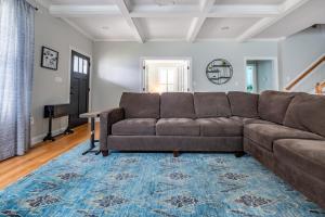 sala de estar con sofá marrón y alfombra azul en Spacious Home in Five Points - Close to Downtown home, en Raleigh