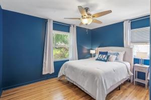a blue bedroom with a bed and a ceiling fan at BeHome Your Cozy, Fun Getaway in Richfield