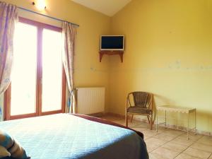 ein Schlafzimmer mit einem Bett und einem Fernseher an der Wand in der Unterkunft Lèdre in La Bastide-de-Sérou