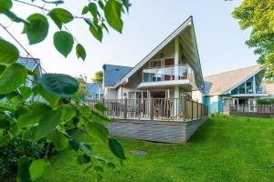 a house with a large porch with a deck at Trewhiddle Retreat V11 by Together Travel - Luxury 4-Bedroom Villa in St Austell