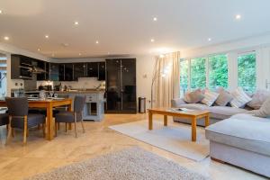 a living room with a couch and a table at Trewhiddle Retreat V11 by Together Travel - Luxury 4-Bedroom Villa in St Austell