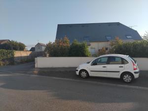 a white car parked on the side of a street at Maison en résidence in Langueux