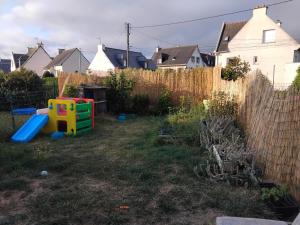 a backyard with a play set and a fence at Maison en résidence in Langueux