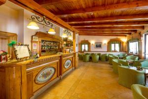a restaurant with a bar with green chairs at Hotel Trieste in Roccaraso