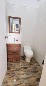 ein Badezimmer mit Toilette, Waschbecken und Spiegel in der Unterkunft Residencia en Tarapoto Casa San Pedro in Tarapoto