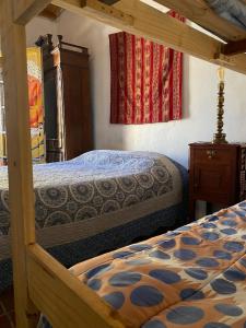 a bedroom with two bunk beds and a dresser at Gran Casa Hostel y Camping in Tilcara