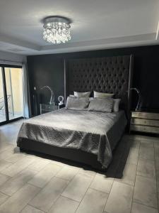 a bedroom with a large bed and a chandelier at Riviera Beach Condo in Rosarito +41 photos