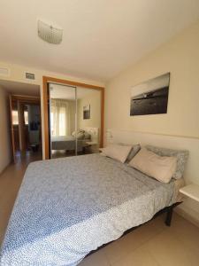 a bedroom with a large bed and a mirror at Paraíso Vera Playa in Playas de Vera