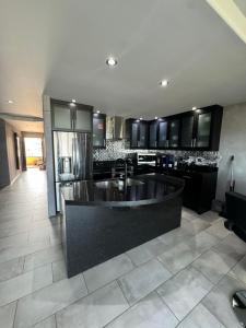 a kitchen with a large black island in the middle at Riviera Beach Condo in Rosarito