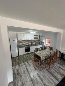 a kitchen and dining room with a table and chairs at Azuga Home in Azuga