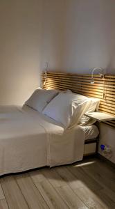 a bedroom with a white bed with a light on the wall at Casa Beatrice in Albinia