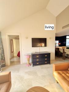 a living room with a tv and a couch at Soto Blues Sotogrande - Puerto Deportivo in Sotogrande