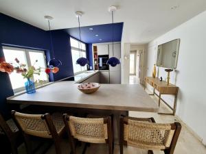 a dining room with a large wooden table and chairs at Soto Blues Sotogrande - Puerto Deportivo in Sotogrande