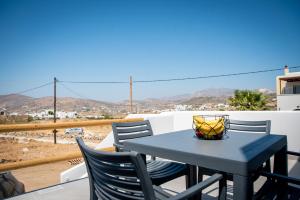 a blue table and chairs on a balcony with a view at Grey Comfort in Glinado Naxos
