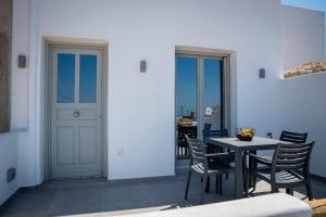 a dining room with a table and chairs and a door at Grey Comfort in Glinado Naxos