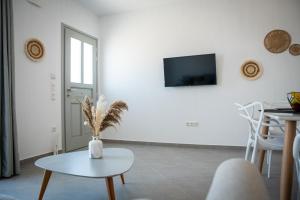 a living room with a table and a tv on a wall at Grey Comfort in Glinado Naxos