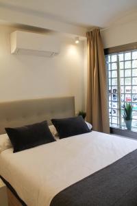 una camera da letto con un grande letto bianco con una finestra di Style Madrid Center Santiago Bernabeu a Madrid