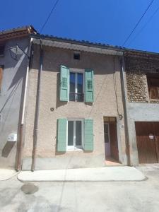 a building with green shutters and a window at Agréable maison en Provence in Allemagne-en-Provence