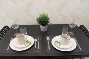 un tavolo nero con piatti bianchi e argenteria di Style Madrid Center Santiago Bernabeu a Madrid Altre 29 foto