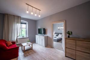 a living room with a red couch and a bed at Pokoje nad Kłodnicą in Gliwice