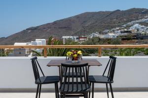a table with a vase of flowers on a balcony at Theophrasti Suites in Foinikiá