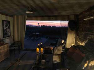 a living room with a couch and a large window at Sunset Log Cabin in Clarksdale