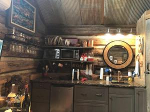 a kitchen with a counter with a sink and a microwave at Sunset Log Cabin in Clarksdale