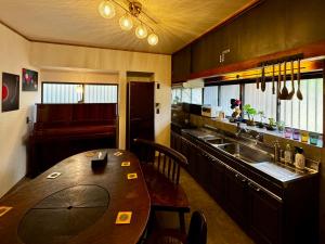 Yawata加美屋リゾート房総 浪漫ラウンジ 夕日と露天風呂-Kamiya Resort Boso的带木桌的厨房和餐厅