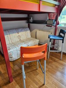 ein Schlafzimmer mit einem Etagenbett, einem Stuhl und einem Schreibtisch in der Unterkunft Studio cosy à la station in Eaux-Bonnes + 13 Fotos