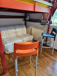 ein kleines Zimmer mit einem Etagenbett und einem Stuhl in der Unterkunft Studio cosy à la station in Eaux-Bonnes