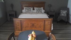 Un dormitorio con una cama y una mesa con bananas. en Chambre d'hôtes La Ruzardière, en Combourtillé