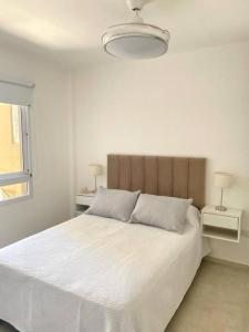 a white bedroom with a large white bed with two lamps at La Martina in Concepción del Uruguay