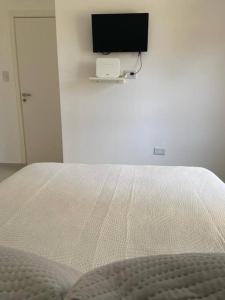 a bedroom with a bed with a television on the wall at La Martina in Concepción del Uruguay