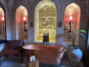 eine Badewanne in einem Zimmer mit einem Stuhl und einer Pflanze in der Unterkunft Mirsoum Han in Mardin