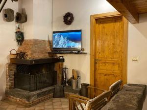 a living room with a fireplace and a flat screen tv at La Rosa antica dell'Etna in Puntalazzo