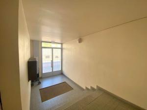 an empty room with a television and a window at Studio tout confort proche des thermes in Vals-les-Bains