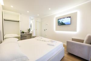 a white bedroom with a bed and a couch at Dadu Rooms in Orikum